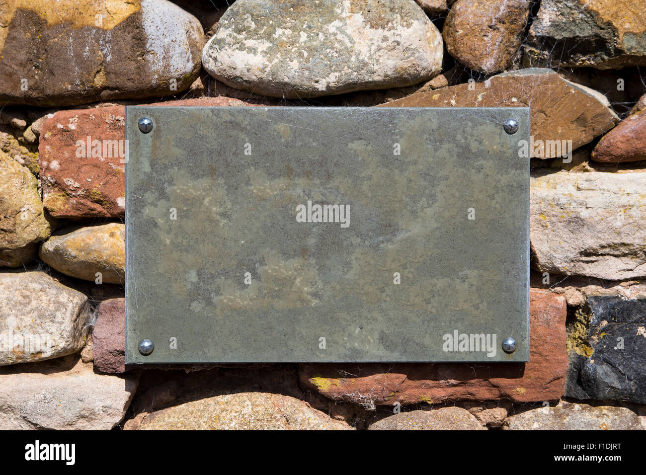 Ein leer, leer, Schiefer Schild an einer Steinmauer mit textfreiraum und keine Schrift. Stockfoto