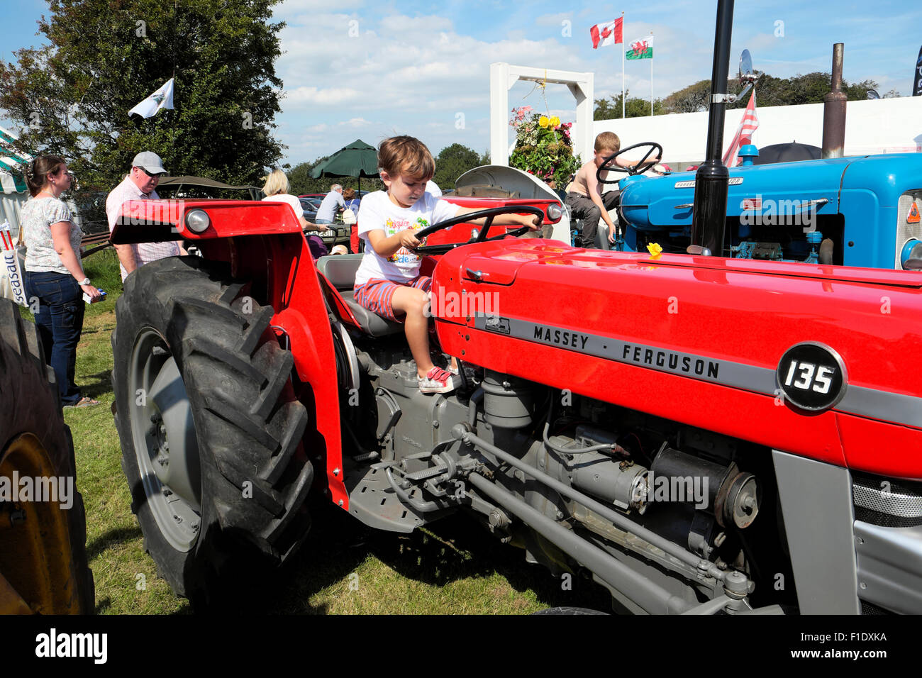 Kind sitzen auf der Fahrt ein Roter Traktor von Massey Ferguson in das Tal von Glamorgan Landwirtschaft zeigen Wales UK 2015 KATHY DEWITT Stockfoto