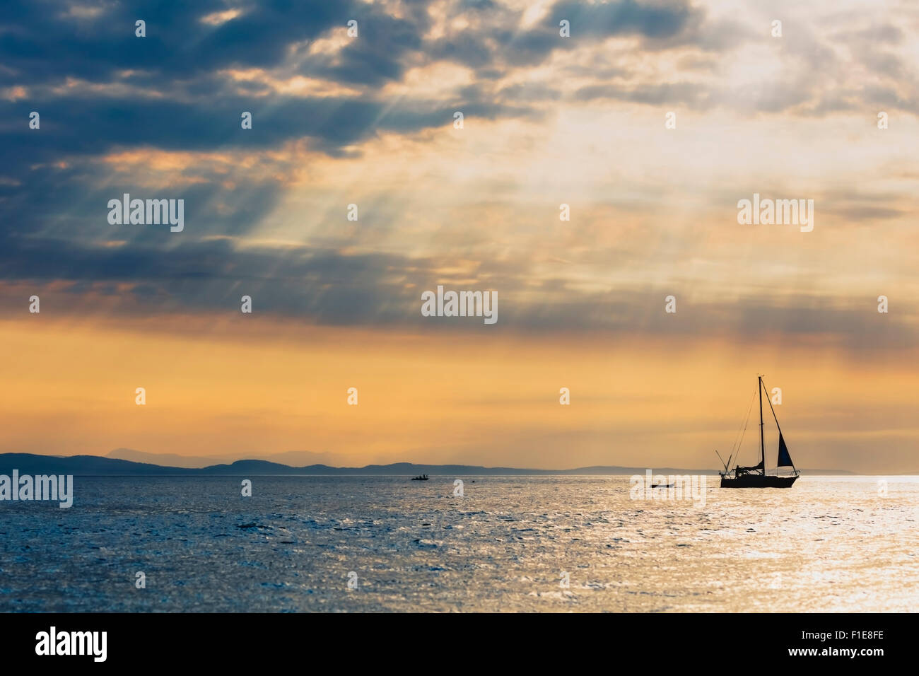 Segelboot Abschleppen wenig Skiff eine Krabbe-Arbeitsboot, alle Silhouette gegen die Verdunkelung Sonnenuntergang von der Salish Sea vorbei. Stockfoto