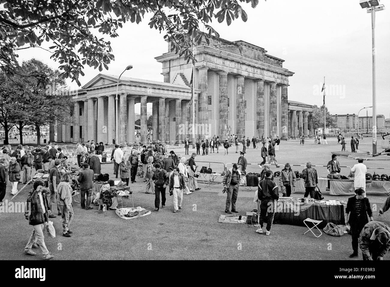 Touristen vor dem Brandenburger Tor, Berlin, 1 Tag vor der Wiedervereinigung von Ost- und Westdeutschland Souvenirs zu kaufen, Stockfoto