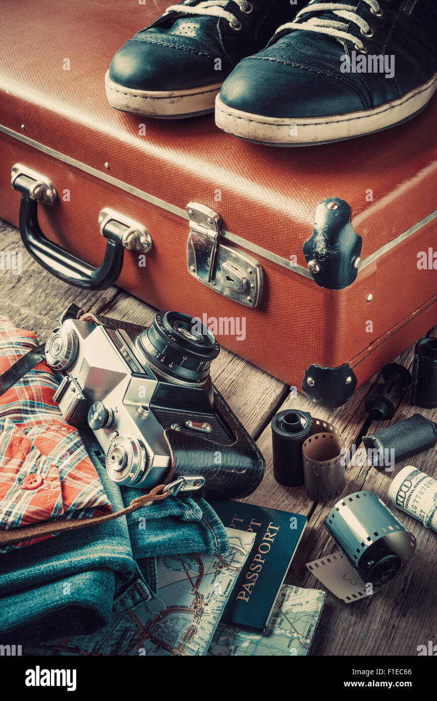 Alte Reisen Koffer, Turnschuhe, Kleidung, Karte, Filmstreifen und Retro-Film-Kamera. Jahrgang stilisiert. Stockfoto