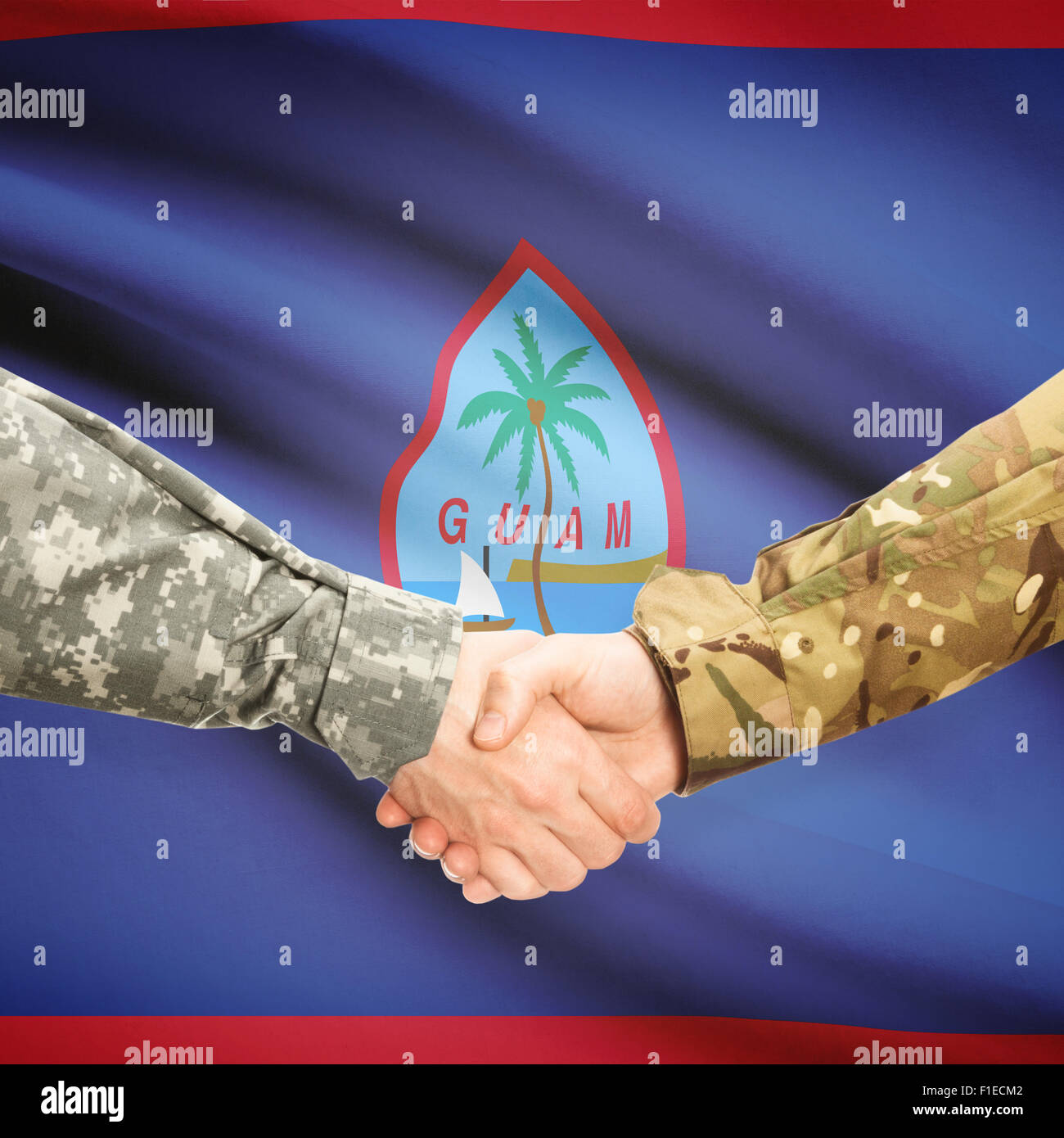 Soldaten, Händeschütteln mit Flagge auf Hintergrund - Guam Stockfoto