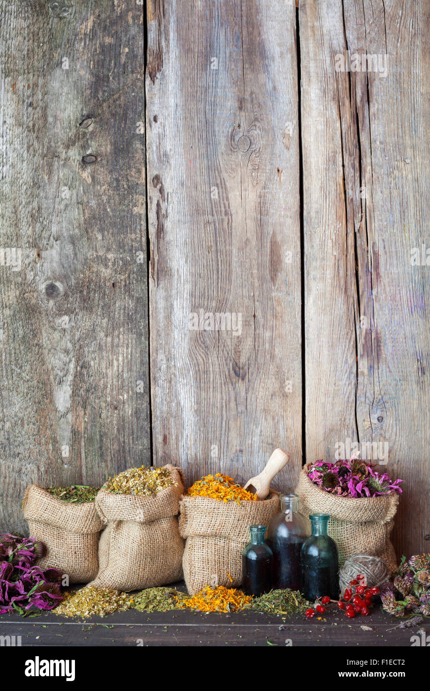 Heilkräuter in Hessischen Taschen auf alten hölzernen Hintergrund, Kräutermedizin. Stockfoto