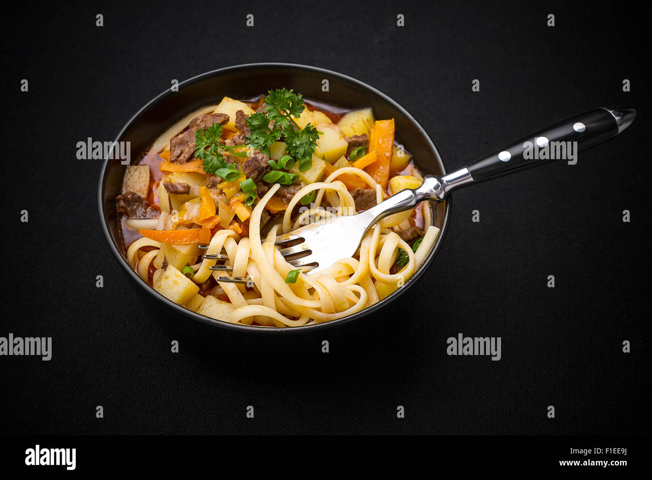 Usbekische Nudelsuppe Lagman auf schwarz, Top Sicht Stockfoto