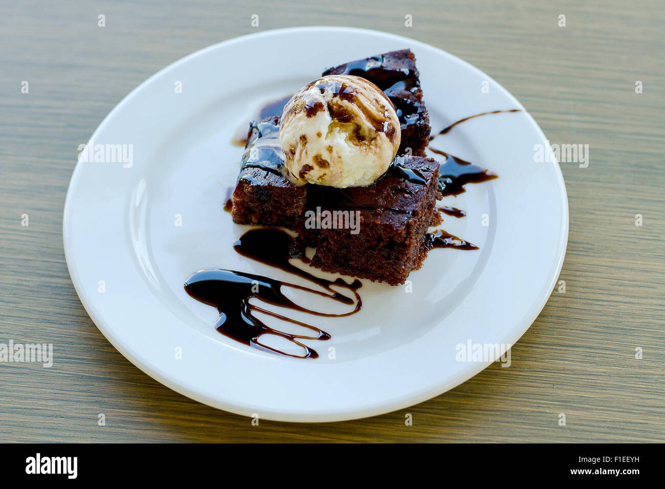 Biskuit-Dessert mit Eis und Schokosauce Stockfoto