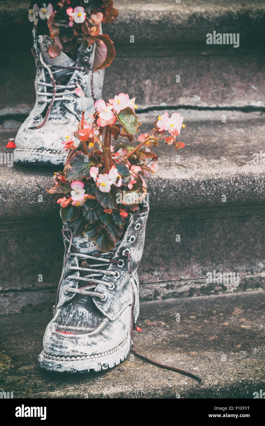 Alte Stiefel mit Blumen als Element der Gartengestaltung. Selektive konzentrieren. Stockfoto