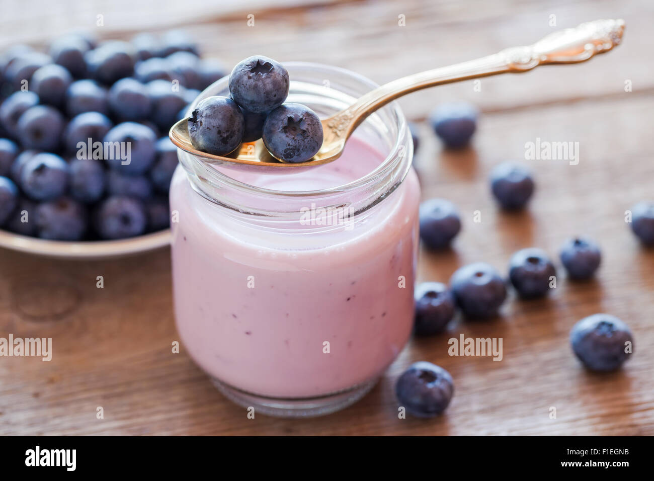 Frische Heidelbeeren Joghurt im Glas und Löffel Stockfoto