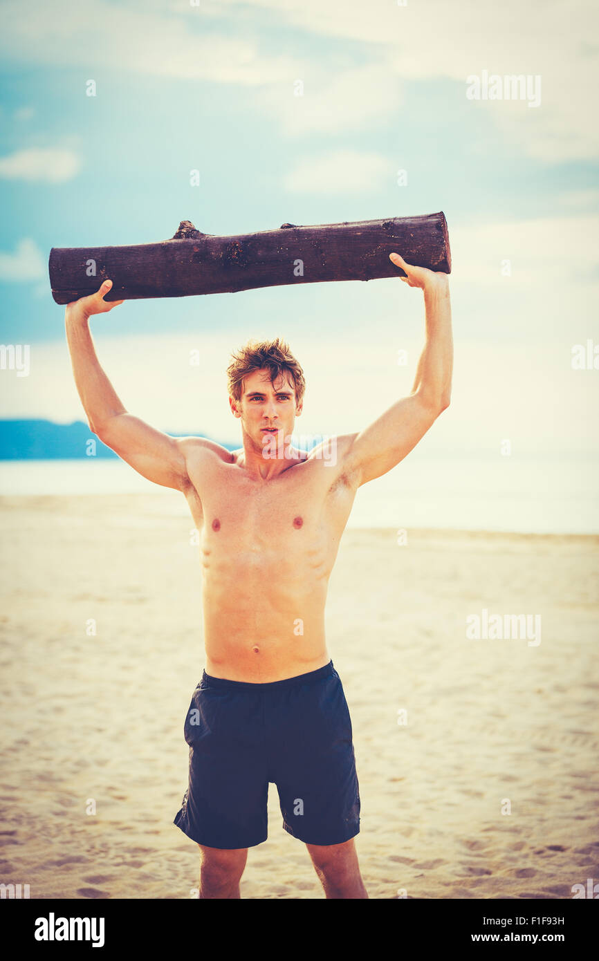 CrossFit Training Strand. Sportler, die Bewegung in der Natur am Strand mit Baum-Protokoll. Fitness und gesunde Lebensweise. Stockfoto