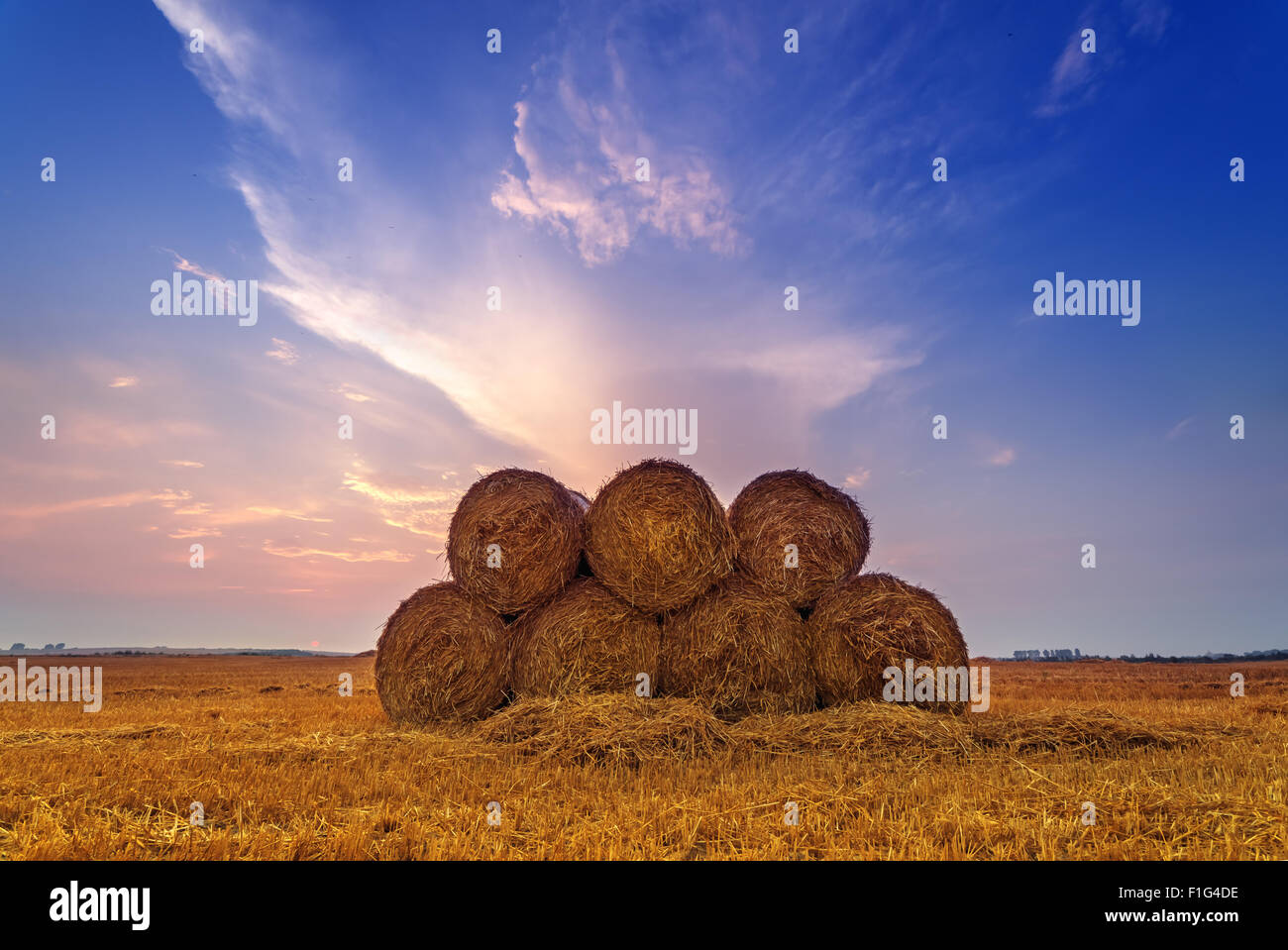Erstaunliche Ländliches Motiv auf Herbst Feld mit Stroh Rollen und dramatische Abendlicht. Stockfoto