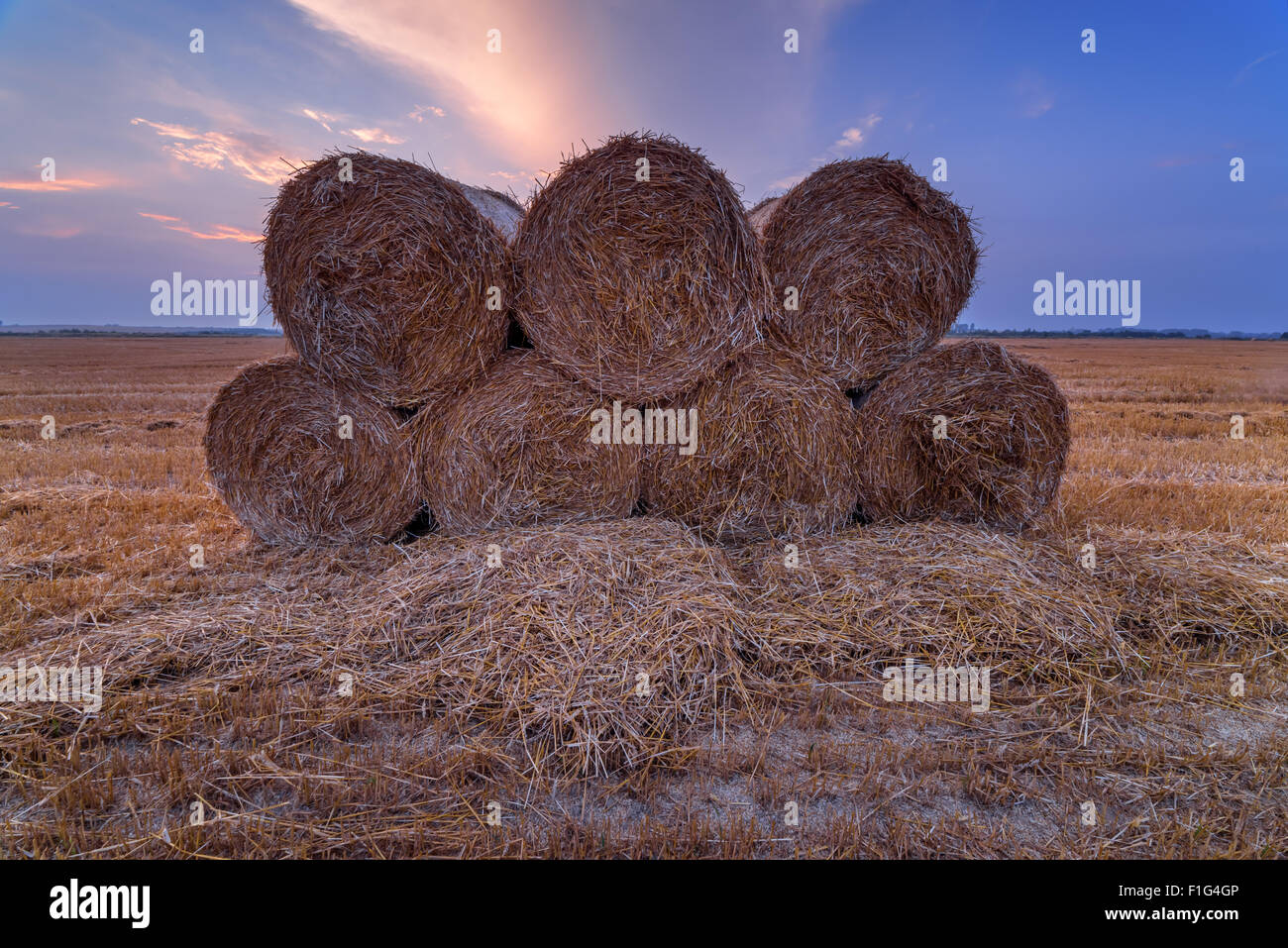 Erstaunliche Ländliches Motiv auf Herbst Feld mit Stroh Rollen und dramatische Abendlicht. Stockfoto