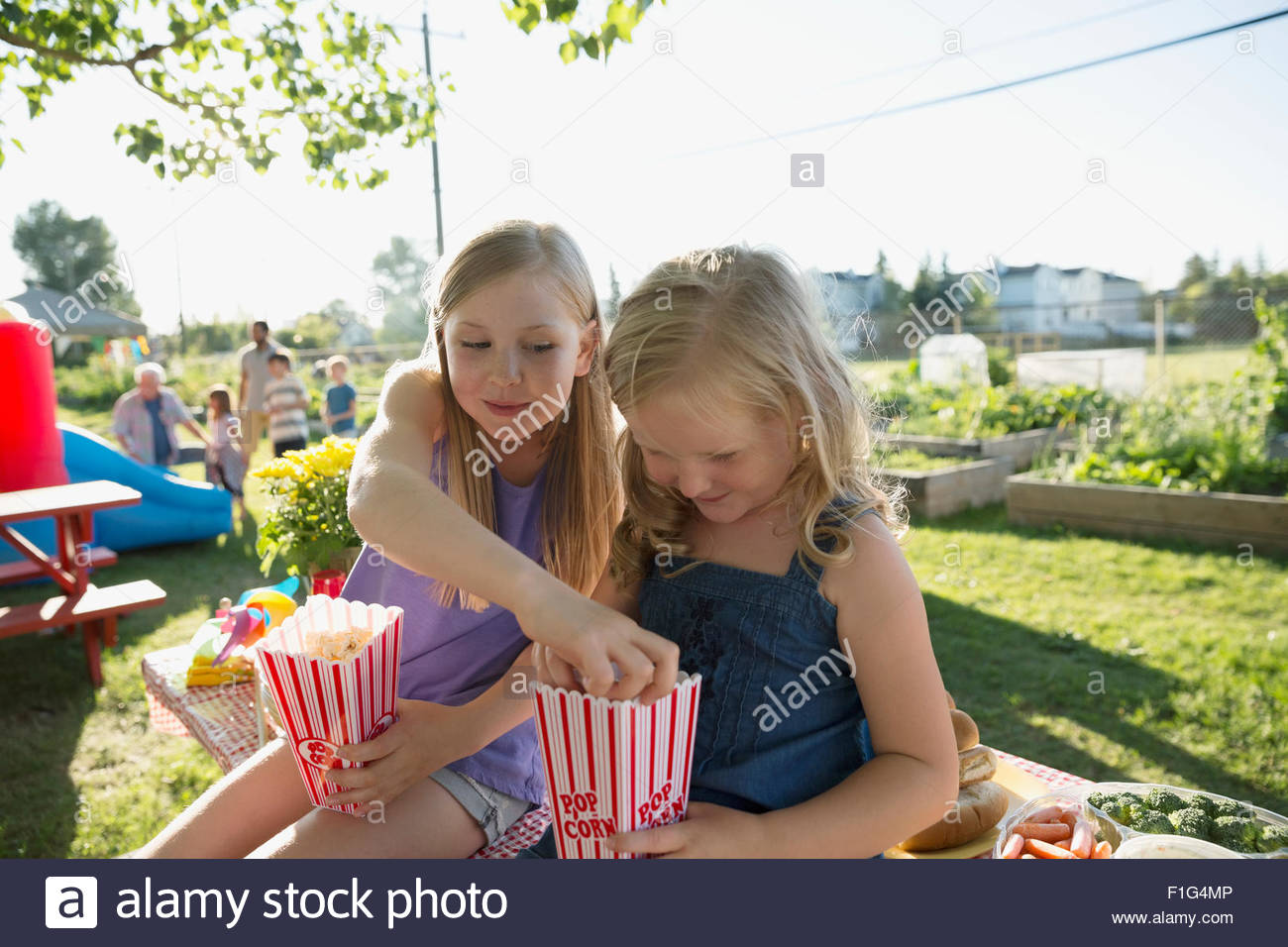Schwestern teilen Popcorn im park Stockfoto