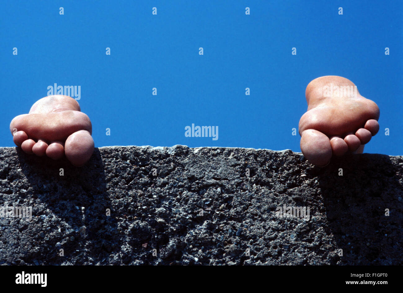 Füße des Kindes an einer Wand Stockfoto