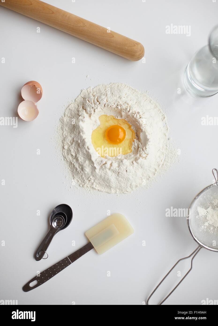 Draufsicht mit rohem Ei im Zentrum der Mehl-Stack und Küchenutensilien Stockfoto