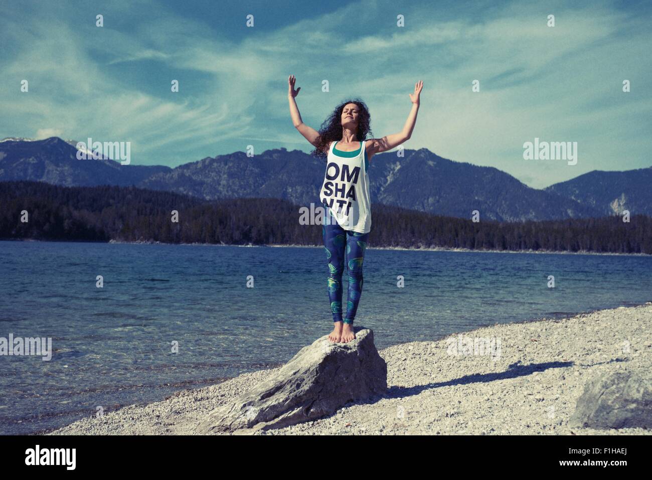Mitte Erwachsene Frau, auf Felsen, in Yogaposition Stockfoto