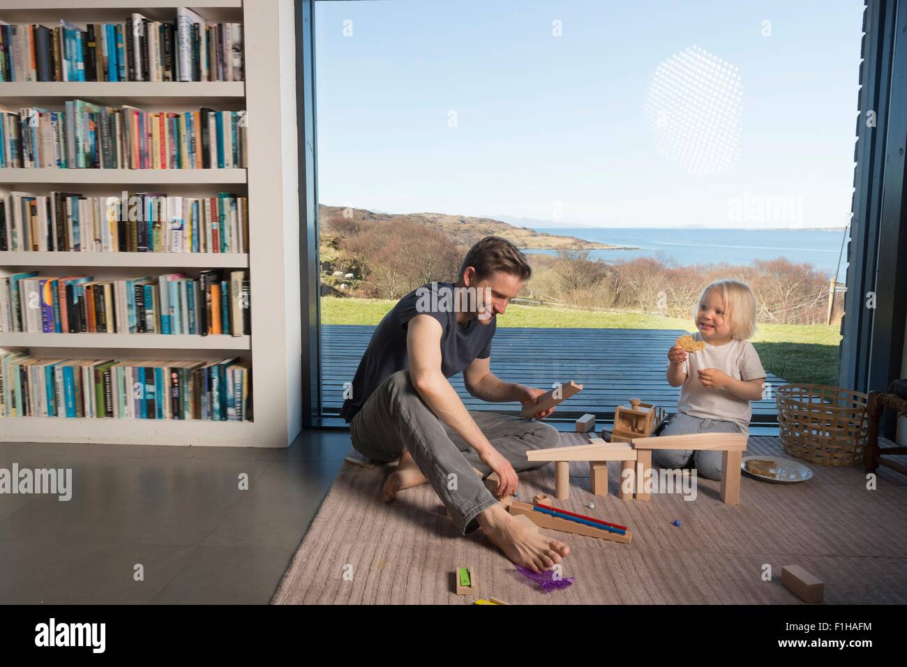 Vater und Sohn spielen mit Holzblöcken zu Hause Stockfoto