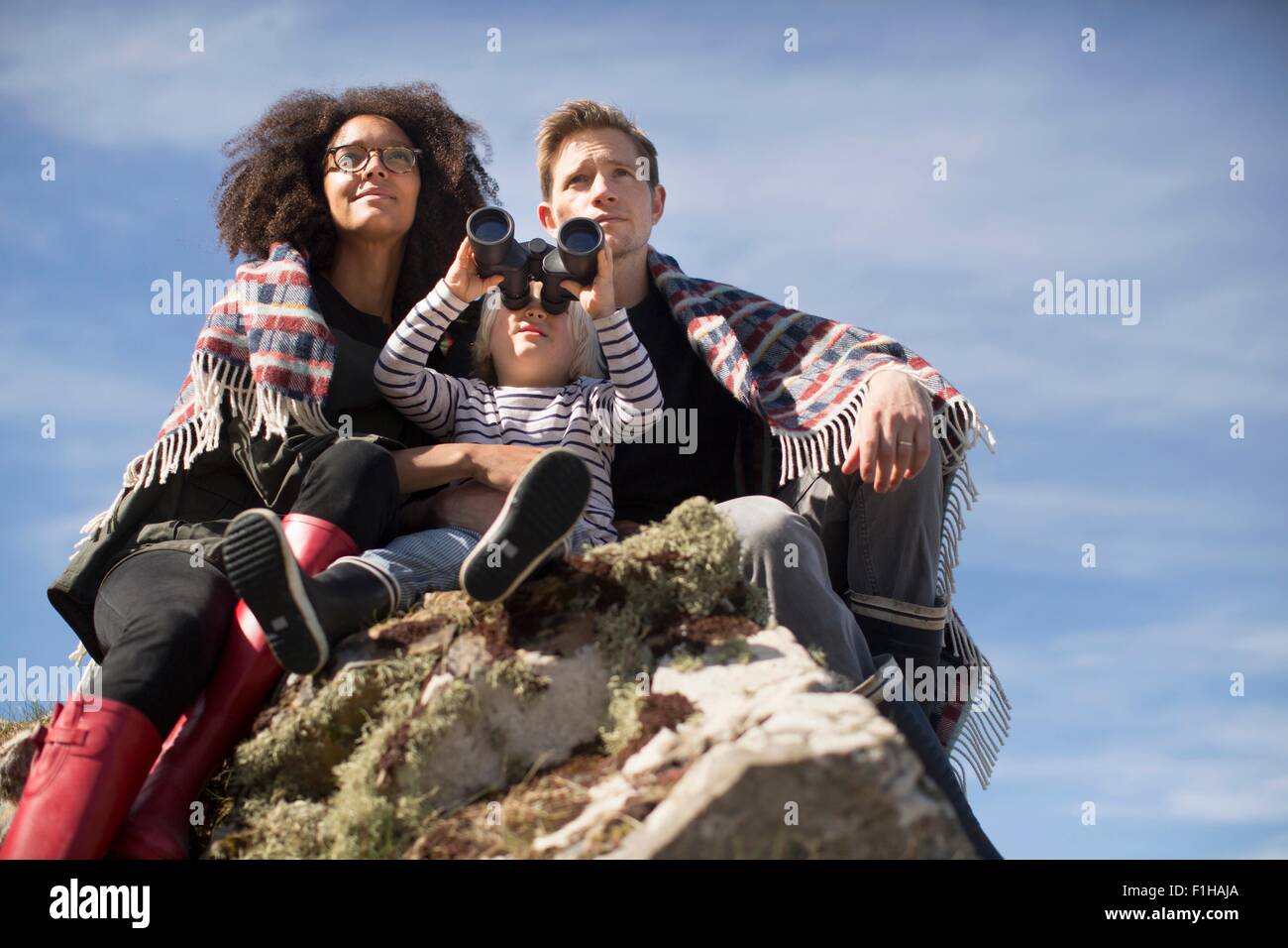 Familie, sitzen auf den Felsen, junge mit binolculars Stockfoto