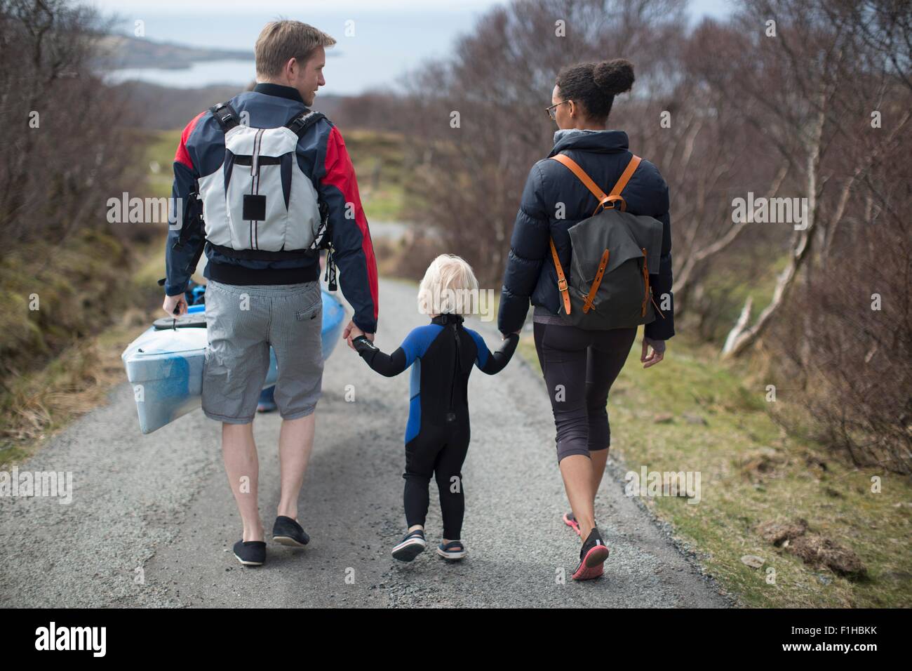 Familie gehen auf Landstraße, die Hand in Hand, Rückansicht Stockfoto