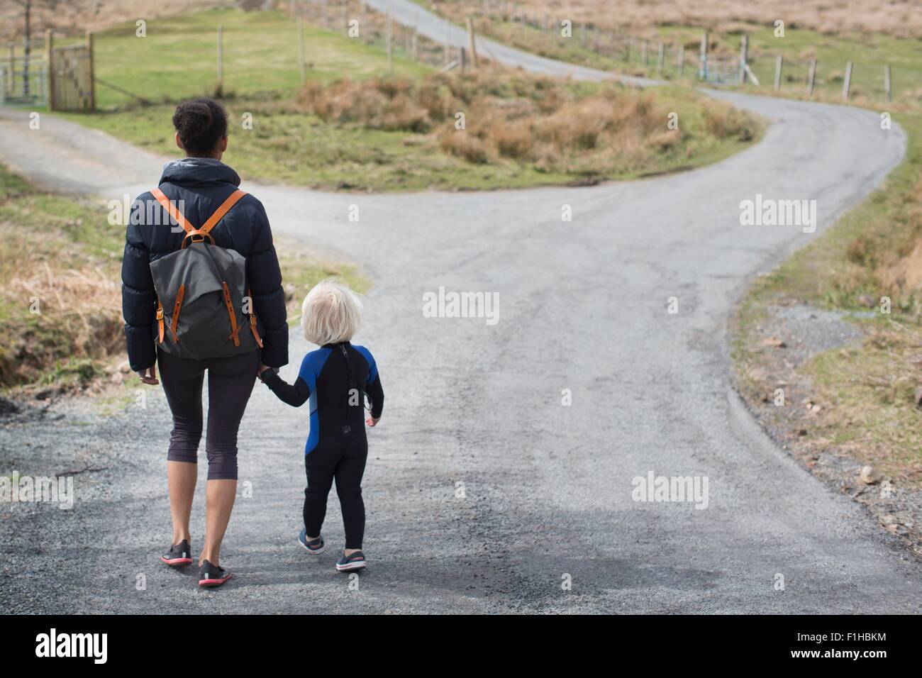 Mutter und Sohn gehen auf Landstraße, die Hand in Hand, Rückansicht Stockfoto