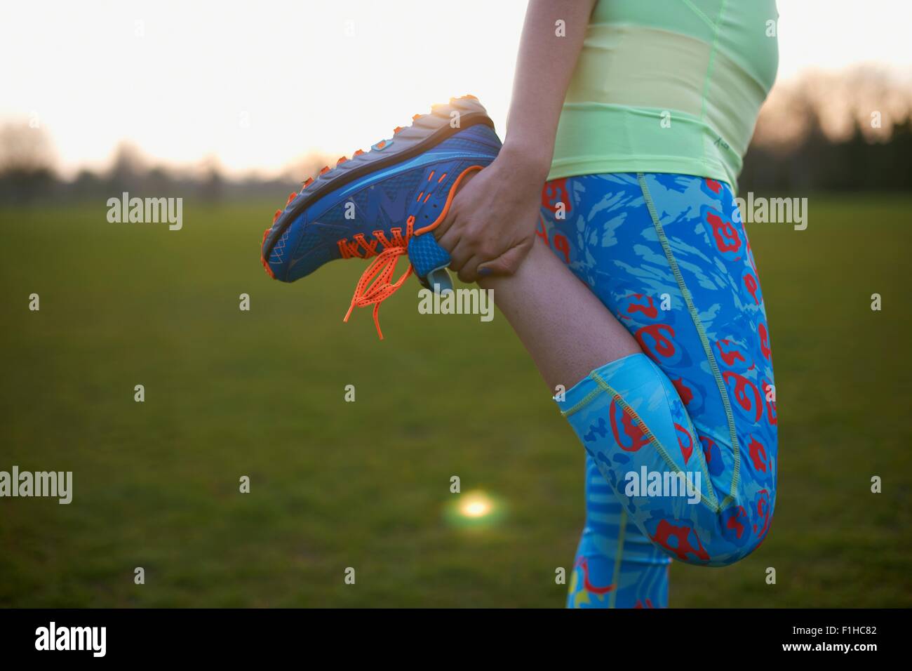 Zugeschnittenes Bild Frau Dehnung Bein Übung im park Stockfoto