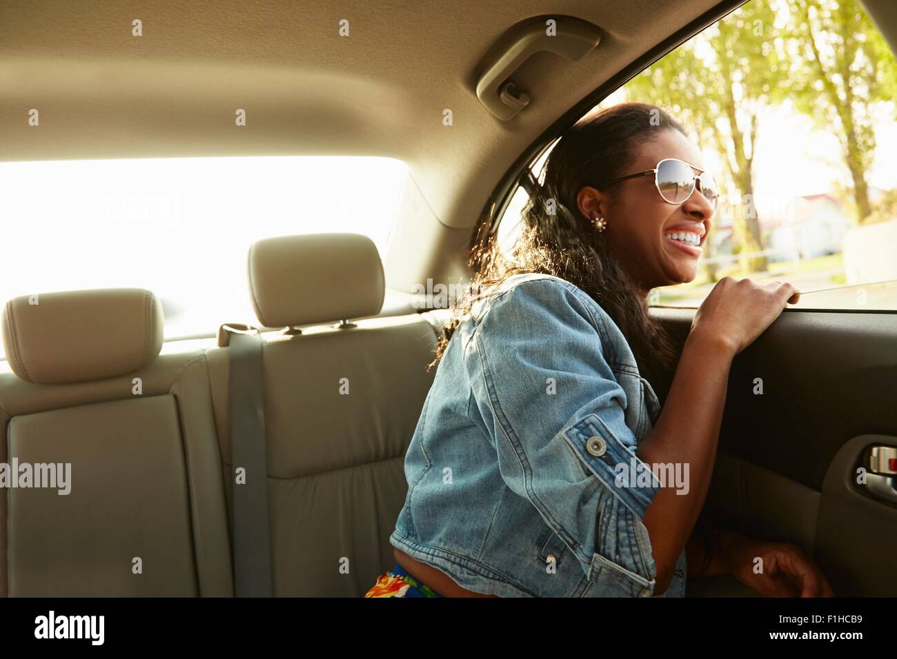 Junge Frau mit Sonnenbrille Blick aus dem Autofenster Stockfoto