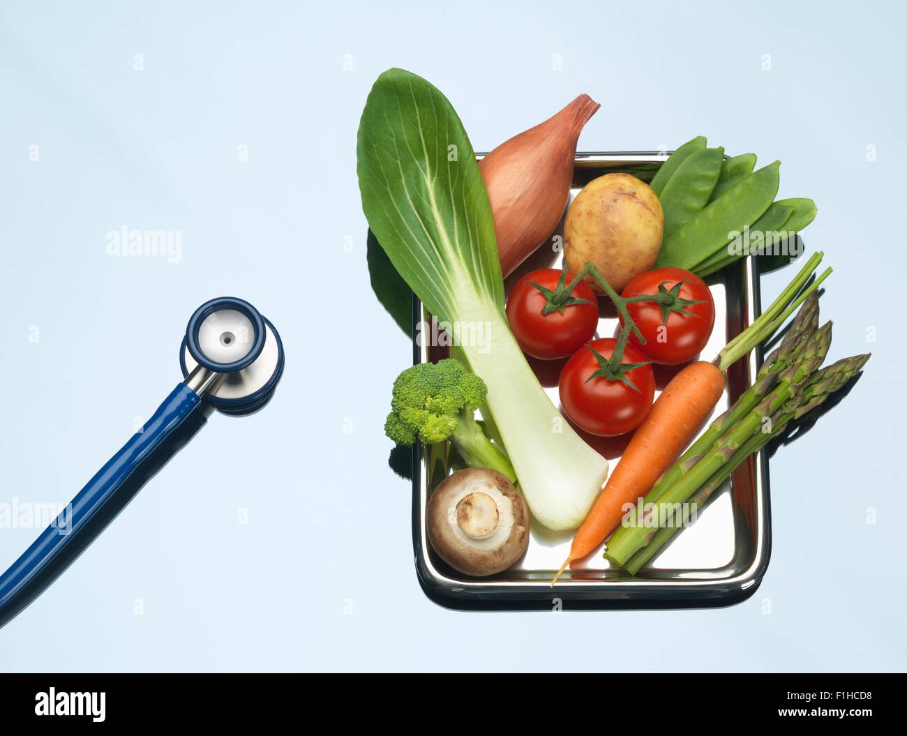 Stethoskop neben Tablett mit frischem Gemüse Stockfoto