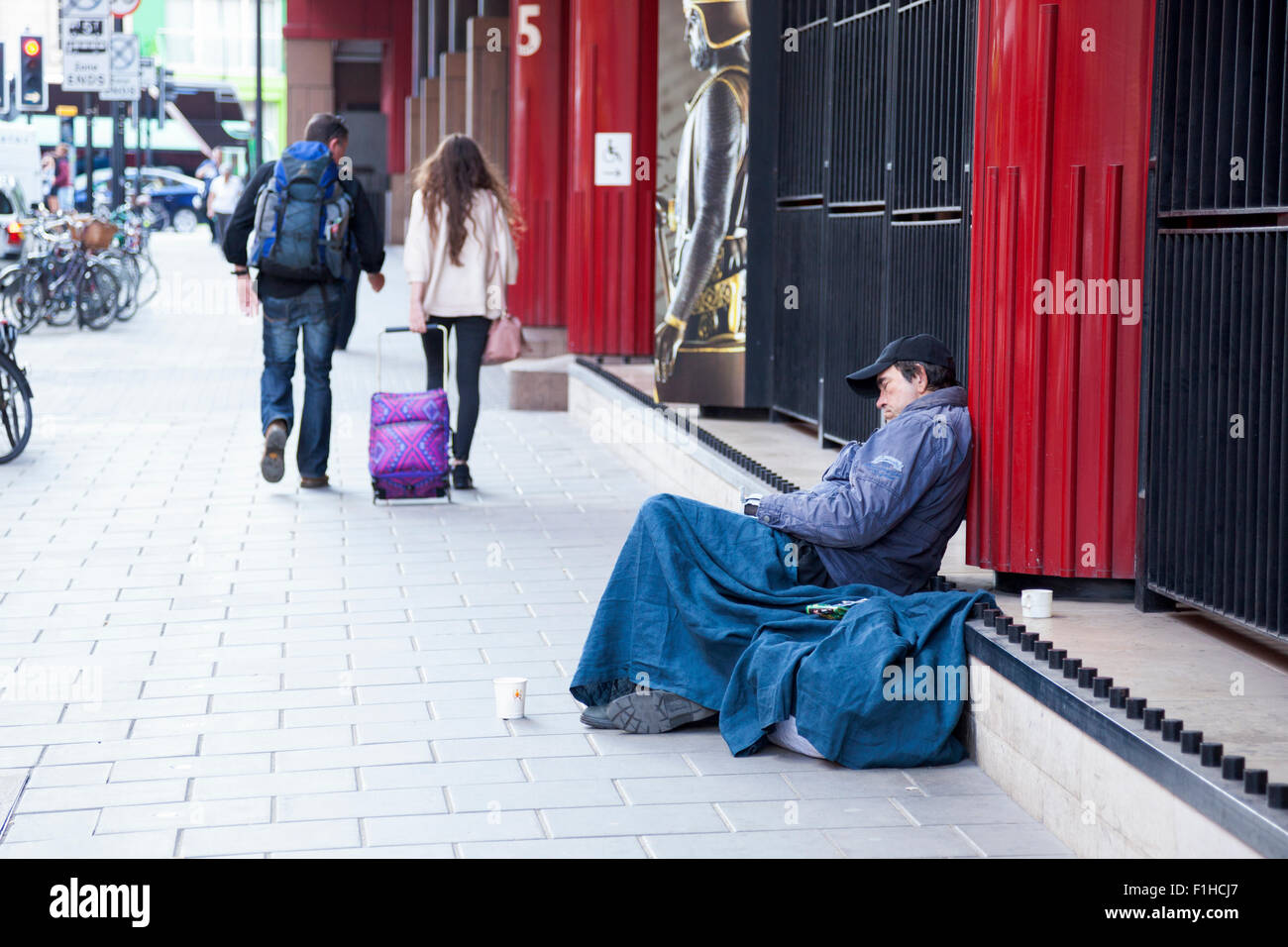 28. August 2015 - ein Obdachloser schläft auf der Straße außerhalb der British Library, London, UK Stockfoto