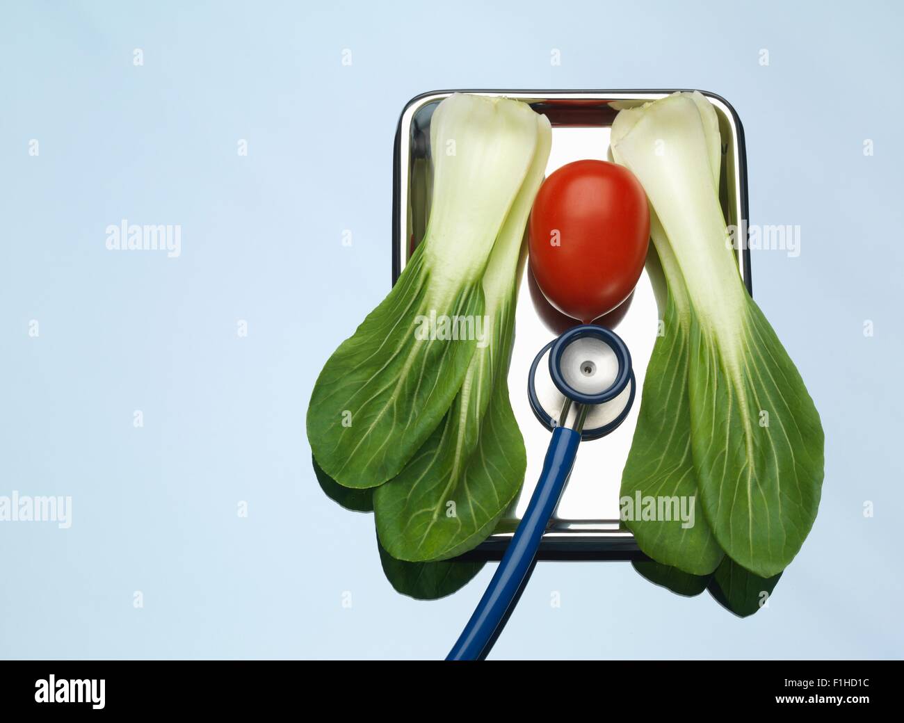 Stethoskop auf medizinische Fach mit einer Tomate und Pak Choi zur Veranschaulichung gesunde Lungen und Herz Stockfoto
