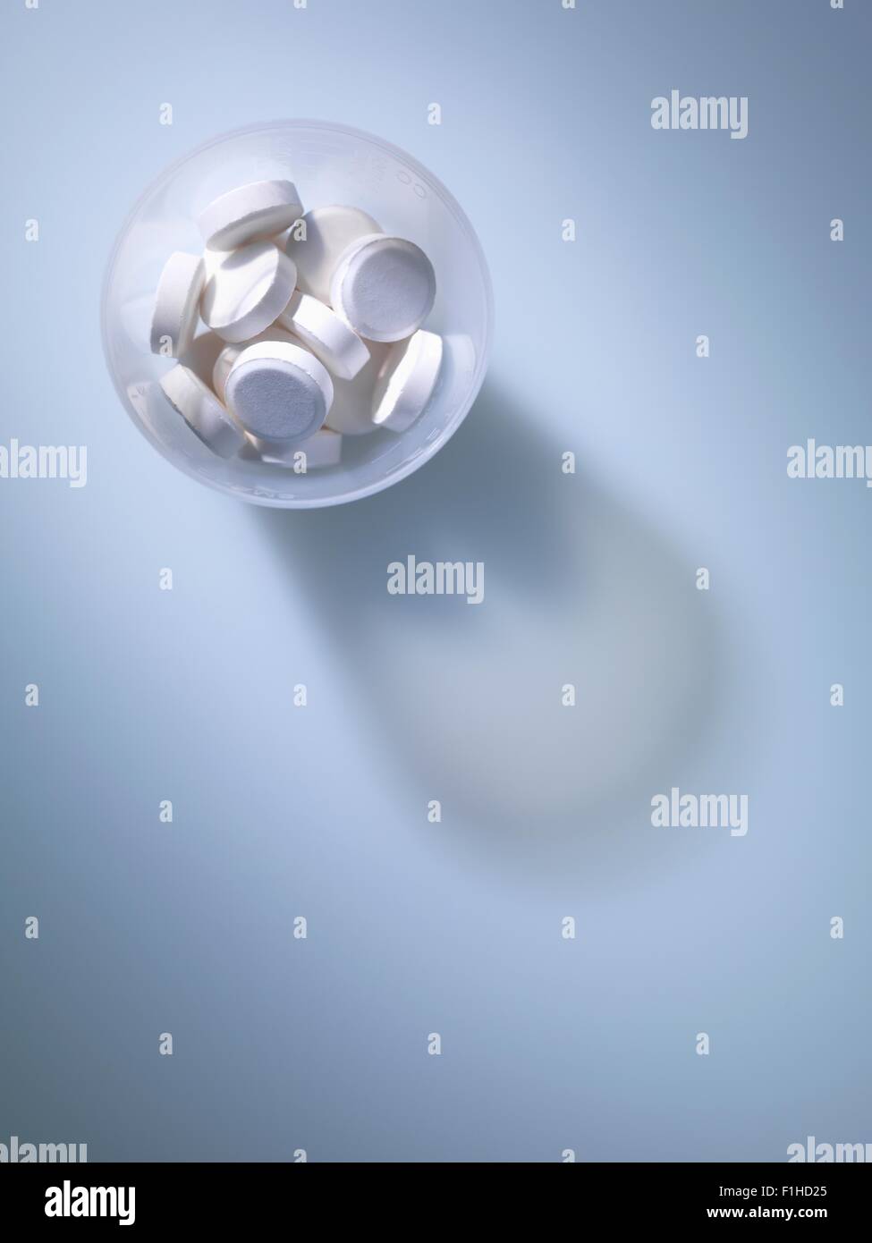 Draufsicht der weißen Tabletten in Kunststoff-Messbecher Stockfoto