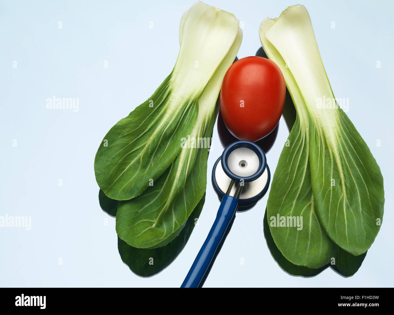 Stethoskop auf einem medizinischen Tablett mit Tomate und Pak Choi, gesunde Lungen und Herz zeigen Stockfoto