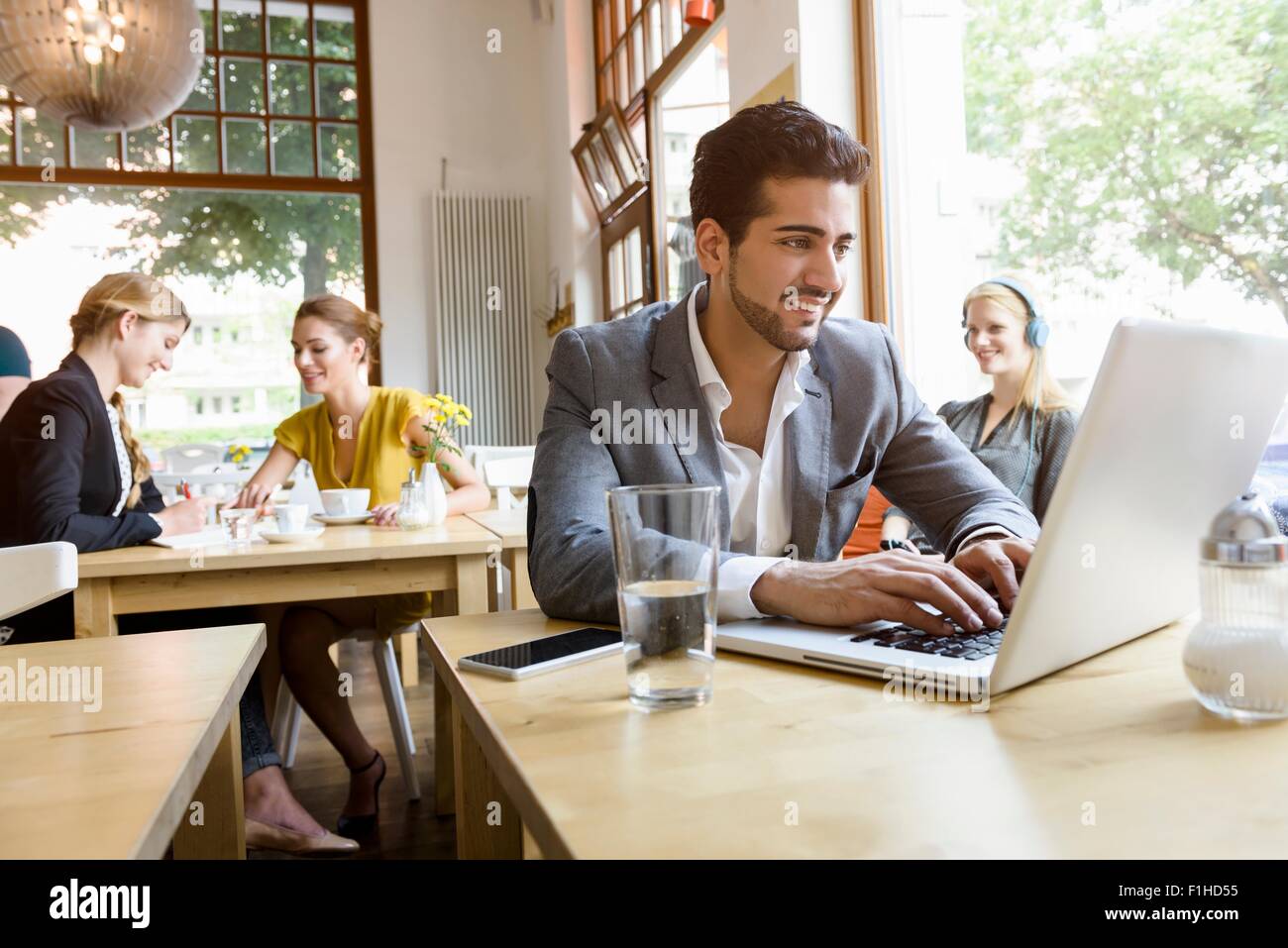 Junger Mann mit Laptop im café Stockfoto