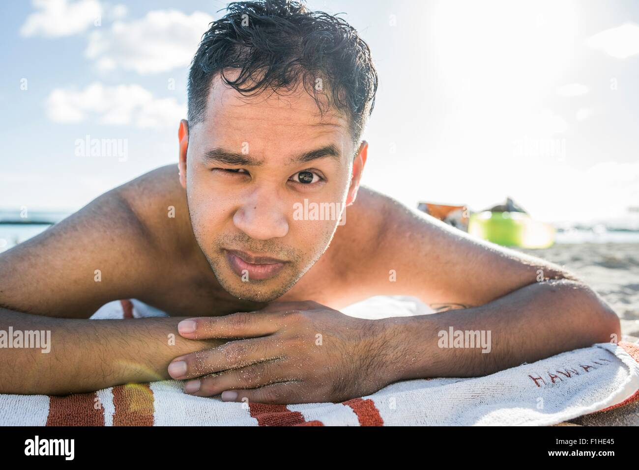Porträt des jungen Mannes, Sonnenbaden am Strand von Waikiki, Hawaii, USA Stockfoto
