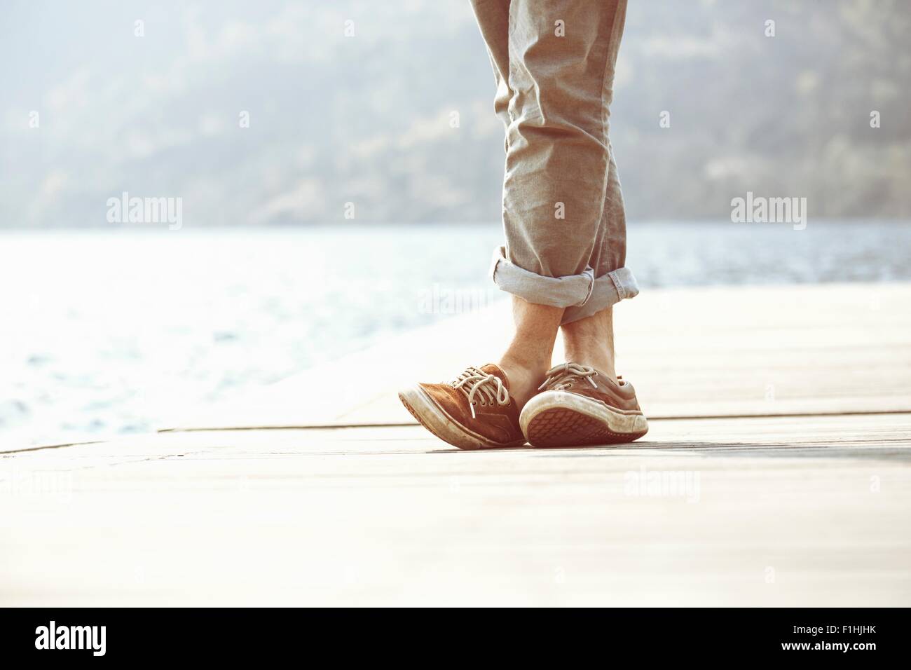 Füße des jungen Mann auf Pier, Mergozzo See, Verbania, Piemont, Italien Stockfoto