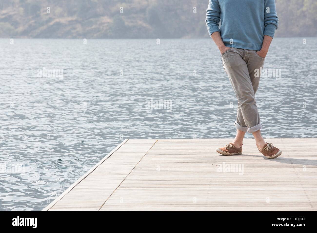 Verkürzte Ansicht der junge Mann auf Pier, Mergozzo See, Verbania, Piemont, Italien Stockfoto