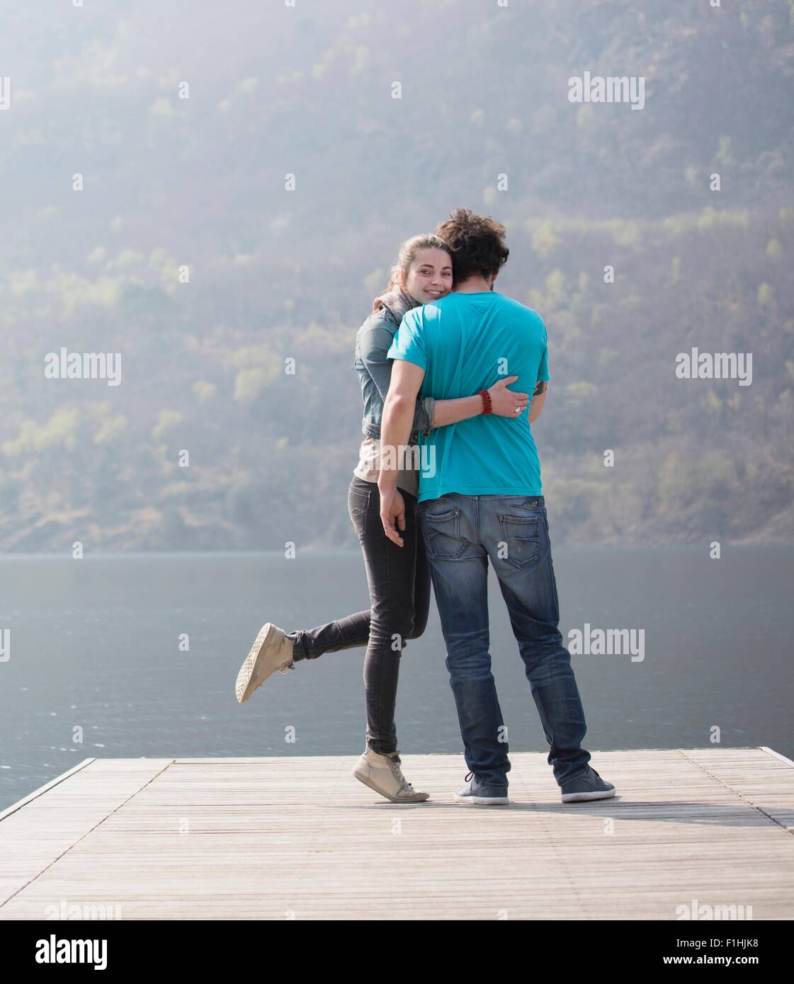 Junges Paar stehend umarmt am Pier am Mergozzo See, Verbania, Piemont, Italien Stockfoto