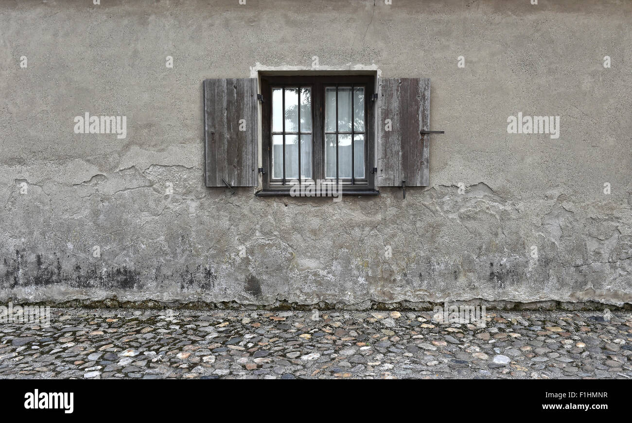 Verwitterte rissige Wand mit alten Holzfenster. Stein Texturen Hintergrund Stockfoto