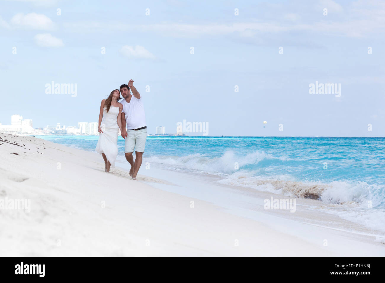 Junge schöne Brautpaar in Liebe Hand in Hand und Fuß am tropischen Sandstrand Stockfoto