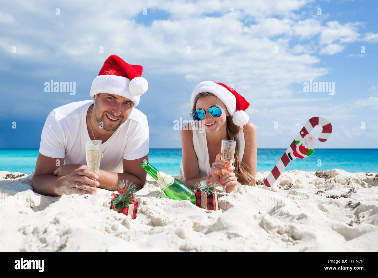 Glückliches Paar feiert Weihnachten am Strand Stockfoto