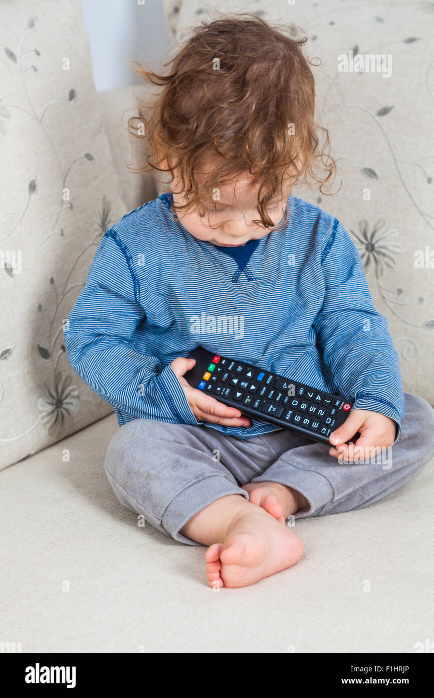 11 Monate altes Baby Boy Studing die TV-Fernbedienung. Stockfoto