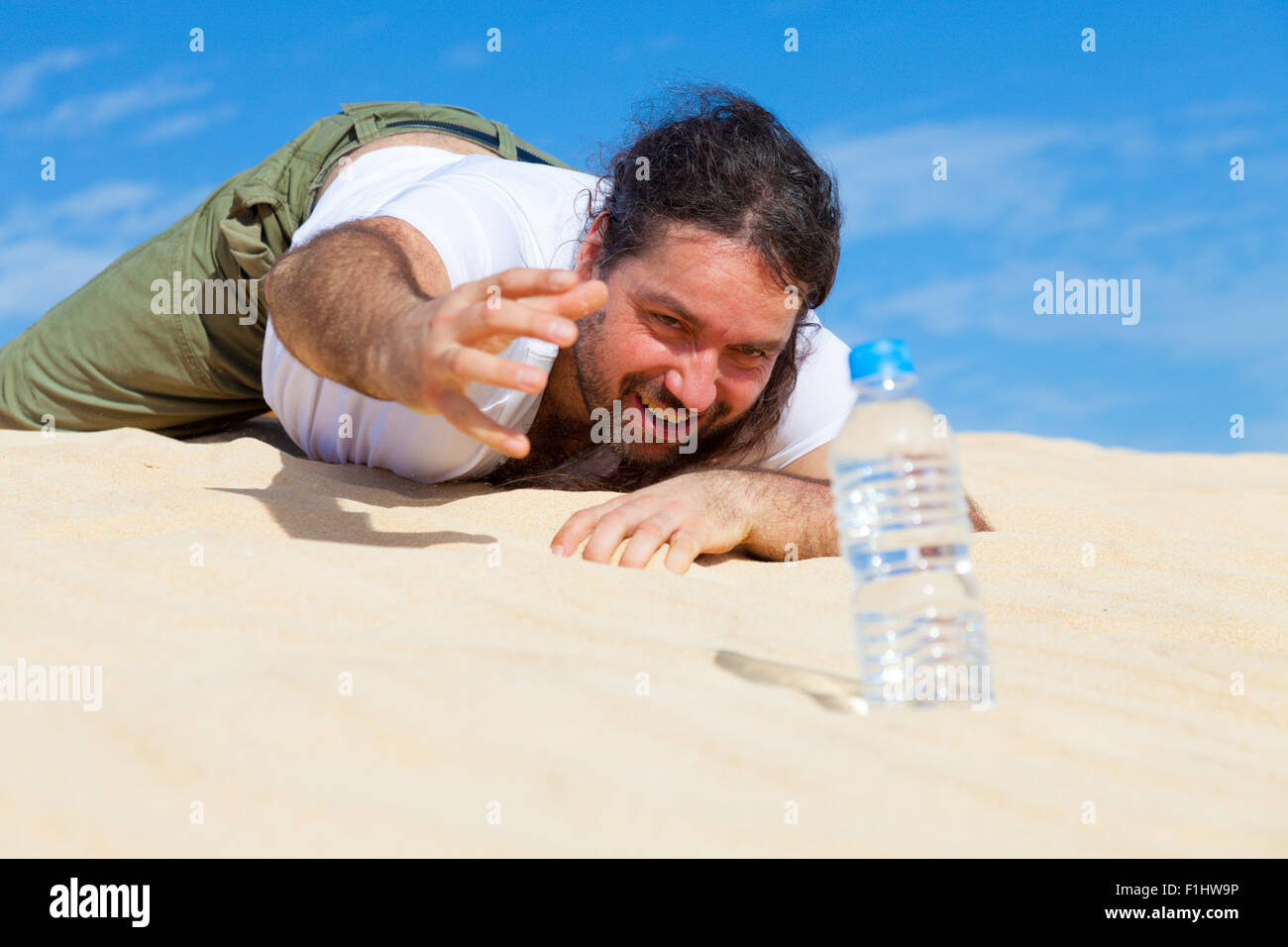 durstige Mann erreicht für eine Flasche Wasser in den leeren Stockfoto