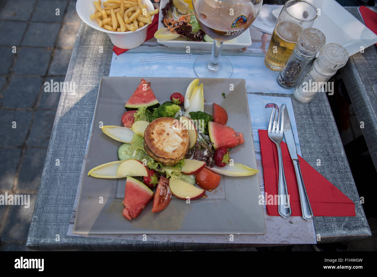 Honig glasierter Ziegenkäse mit einem schönen frischen Salat und ein typisch belgisches Bier.  Speisen zur Mittagszeit in Brügge. Stockfoto