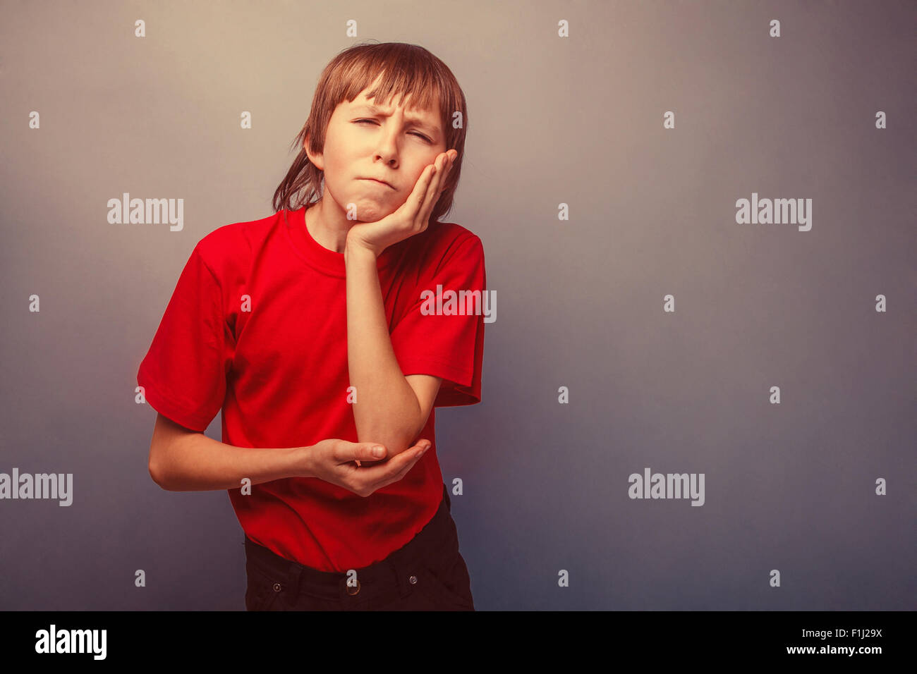 Junge, Jugendliche, zwölf Jahre in die rote retro T-shirt-Zahnschmerzen Stockfoto