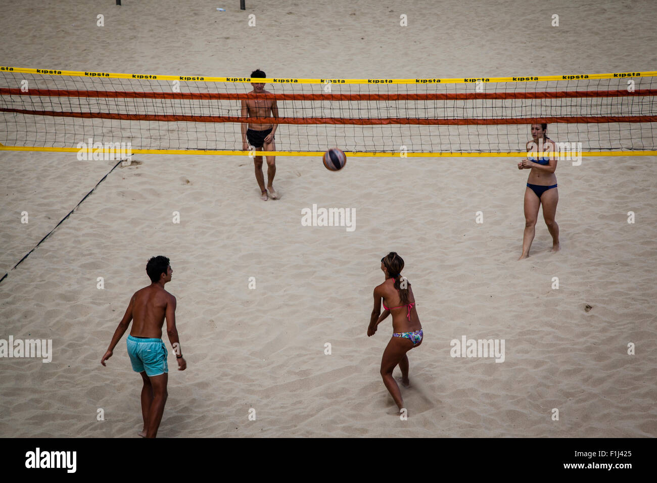 Gruppe von Jugendlichen in Barceloneta Beach-Volleyball spielen Stockfoto