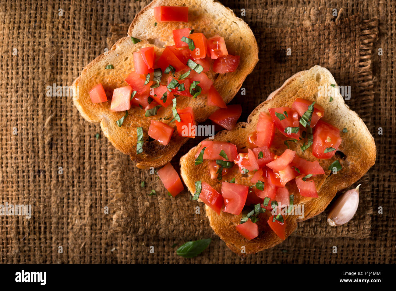 Bruschetta mit Tomaten und Basilikum über alte canvas-Tasche und Raum zu kopieren Stockfoto