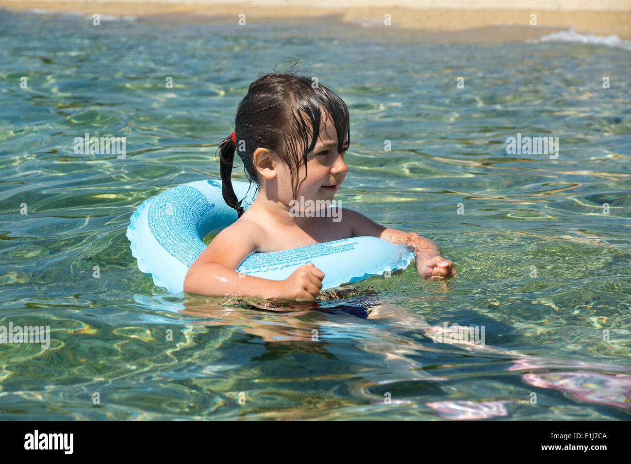 Kind mit Schwimmring Spaß im Meer Stockfoto