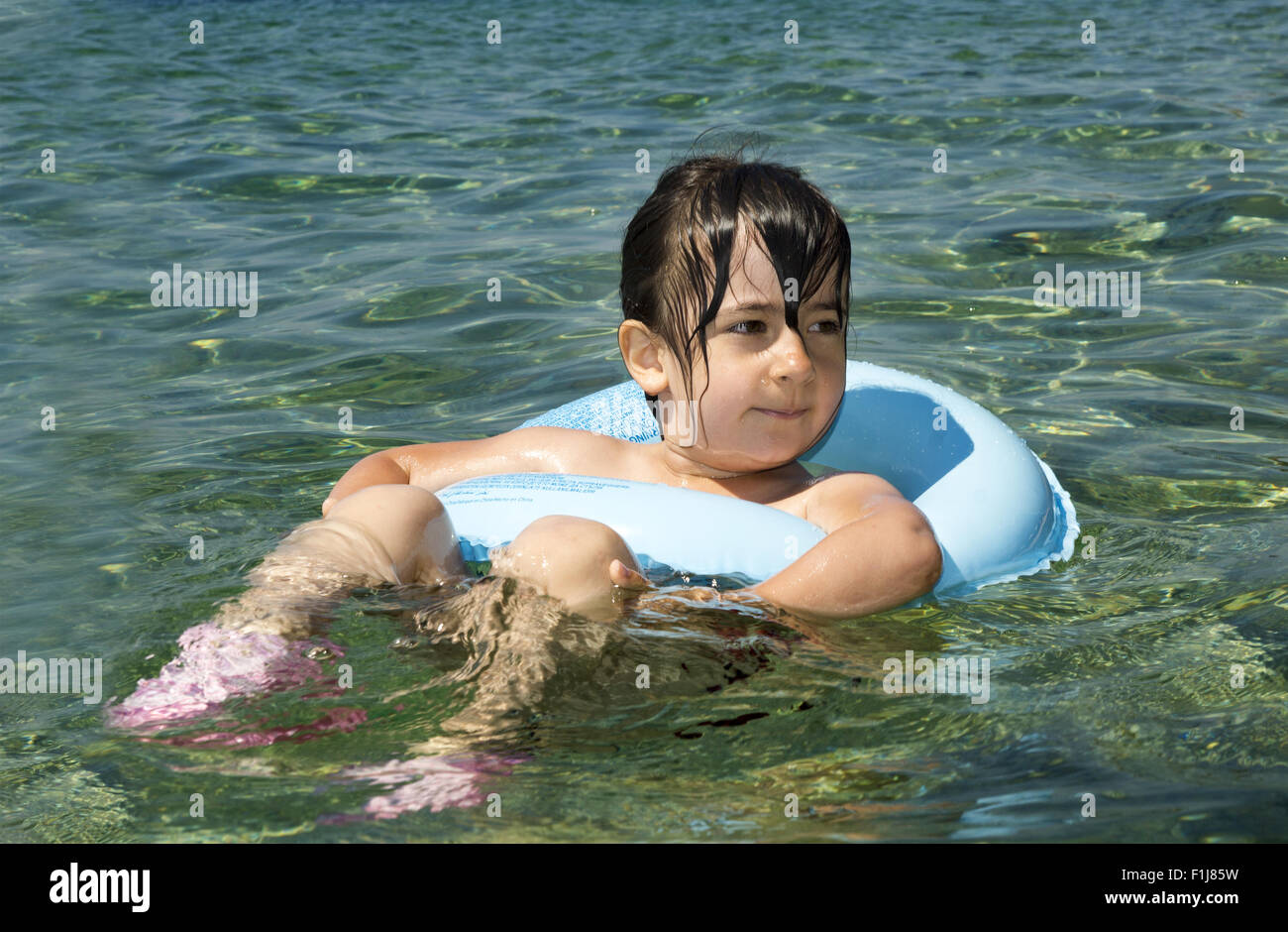 Kind mit Schwimmring Spaß im Meer Stockfoto