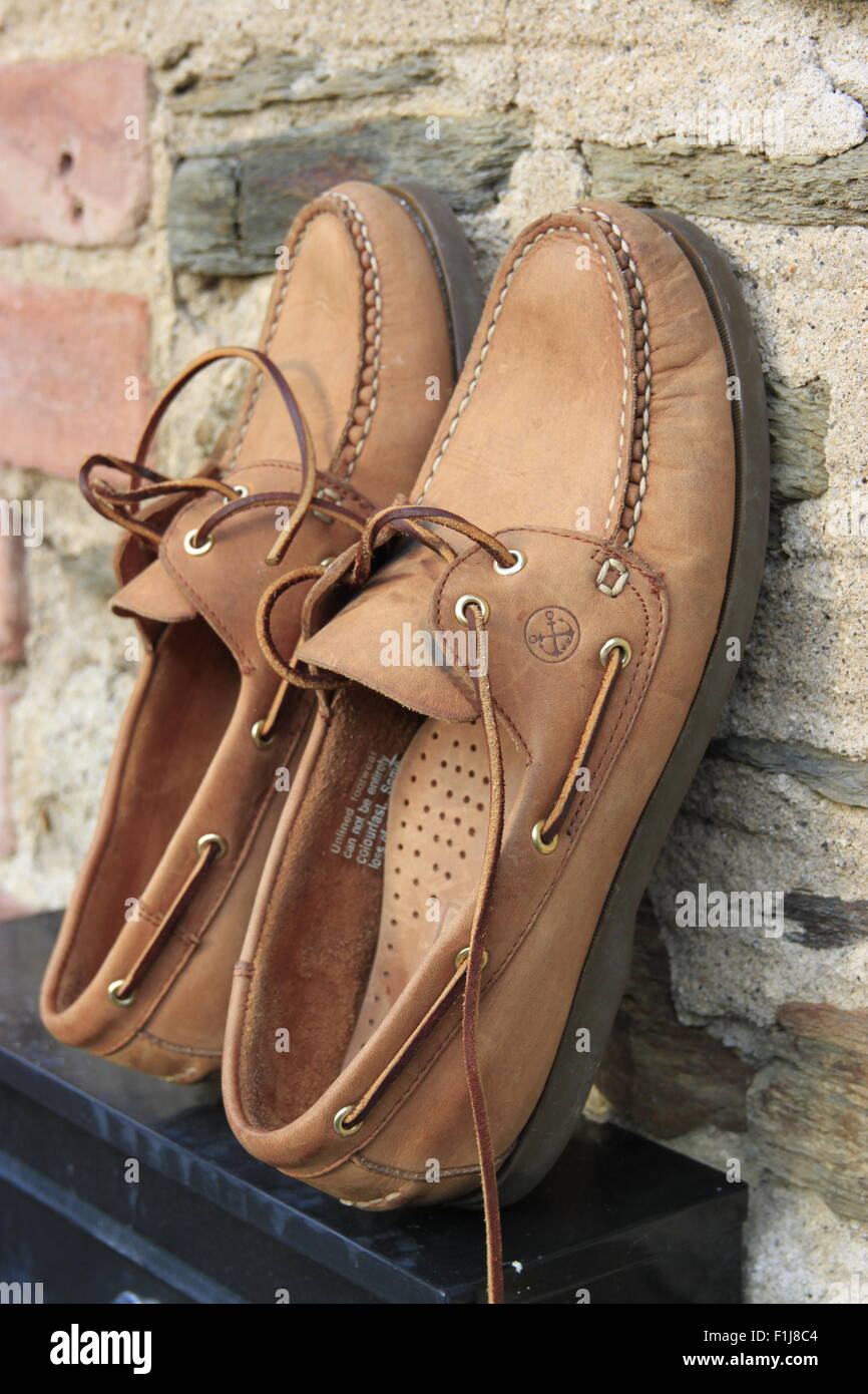 Deck Bootsschuhe trocknen in der Sonne gegen Landhaus aus Stein Wand Cornwall am Meer Stockfoto