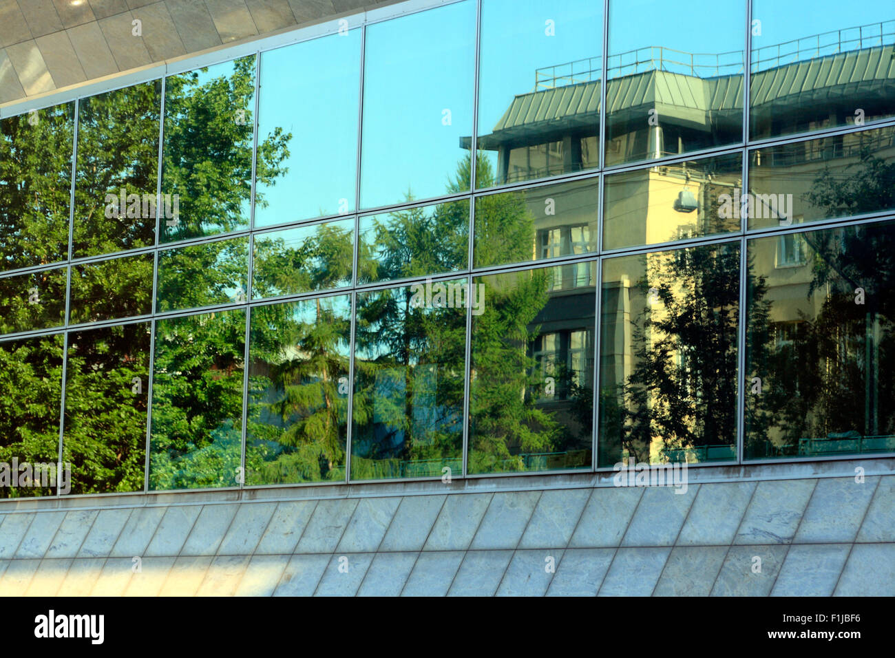 Grünen Bäumen und Haus reflektierte über große Fenster. Stockfoto