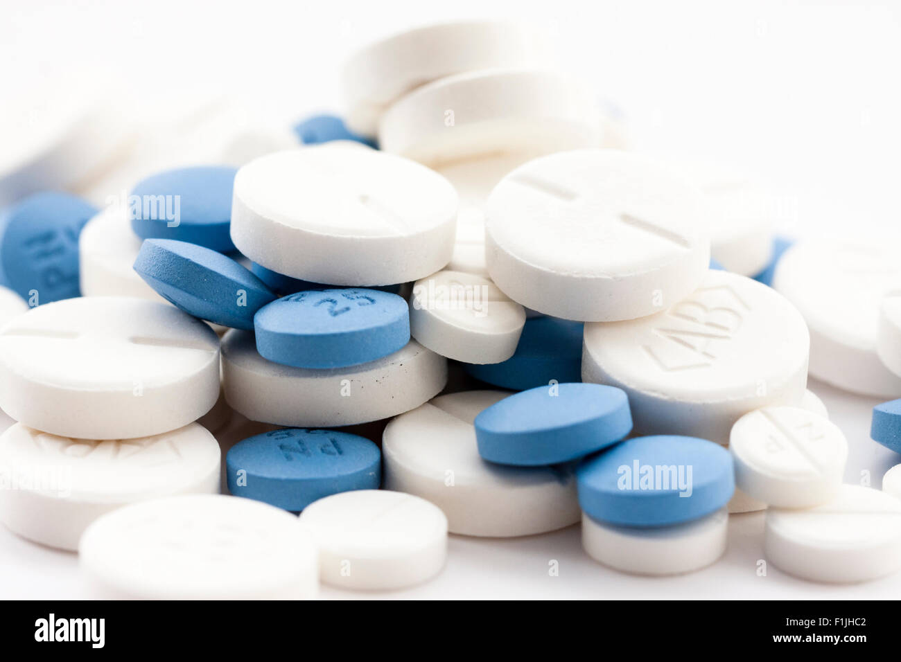 Medikamente. Große weiße und kleinere blaue Tabletten in Stapel auf weißen  Hintergrund Stockfotografie - Alamy