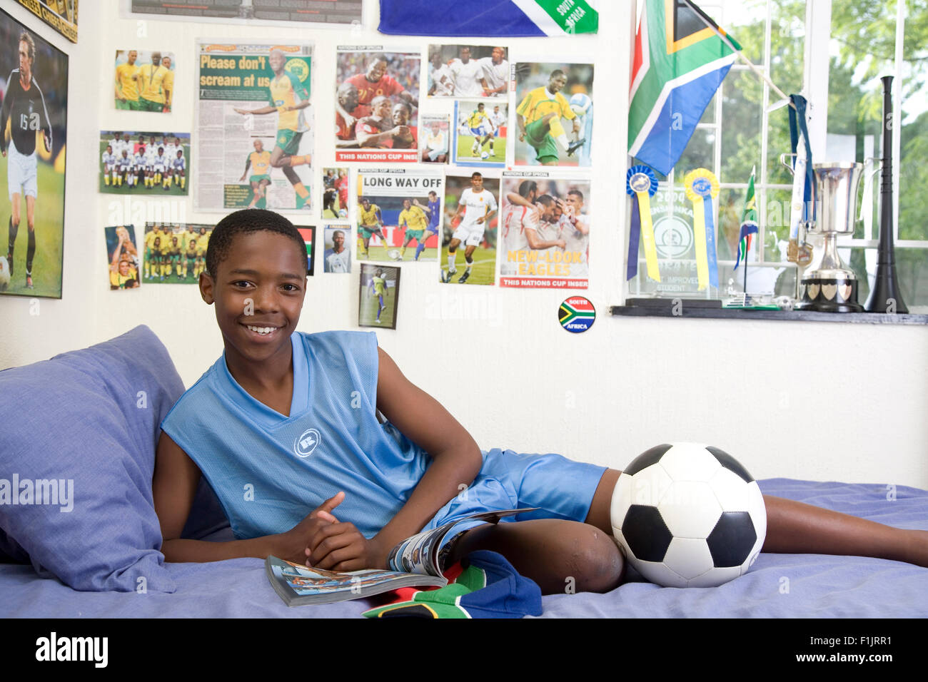 Jungen Fußball-Fan in seinem Schlafzimmer Stockfoto