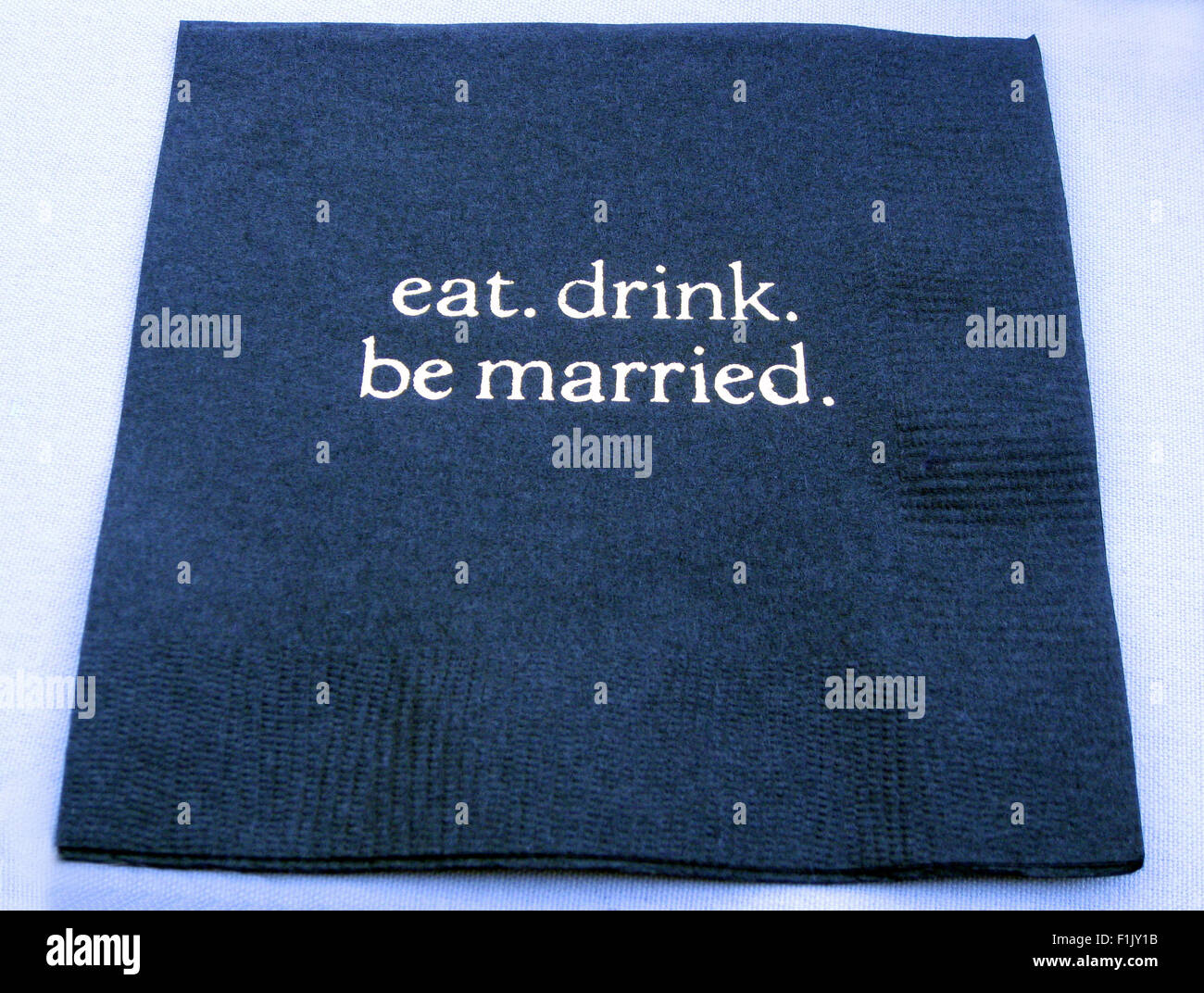 Kleines blaues Papier cocktail Servietten sind geschickt mit eingeprägtem "Essen. trinken. sein verheiratet.' für eine Hochzeitsfeier in San Francisco, Kalifornien, USA. Stockfoto